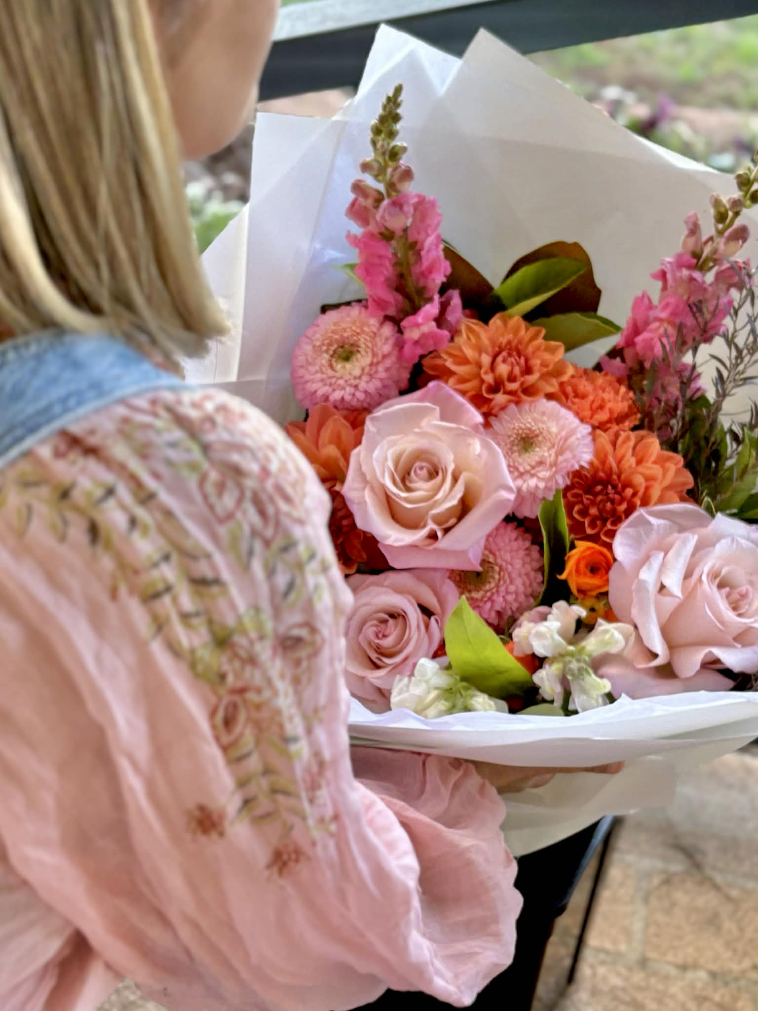 Beautiful bouquet of pinks and oranges - gorgeous sunset colours. A lady is picking them up ready to deliver to someone special! 