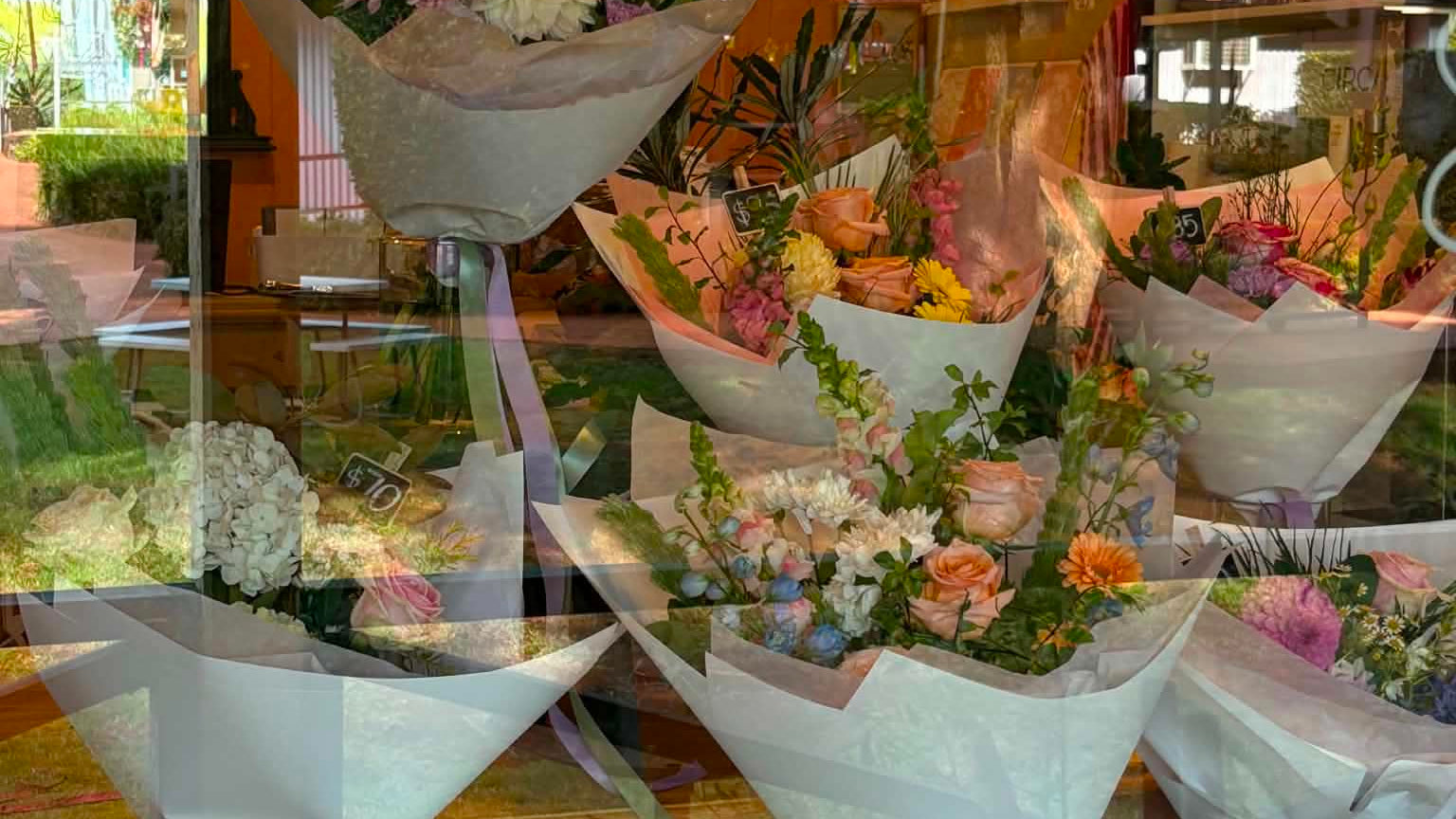 Stunning bouquets of flowers displayed in a store window.